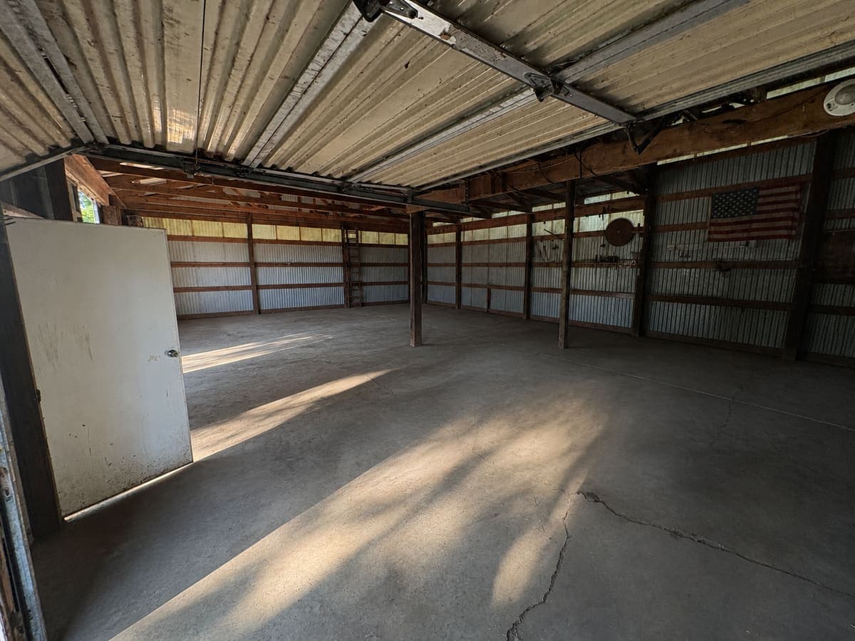 The same barn packed with stored items and debris, then emptied down to bare concrete
